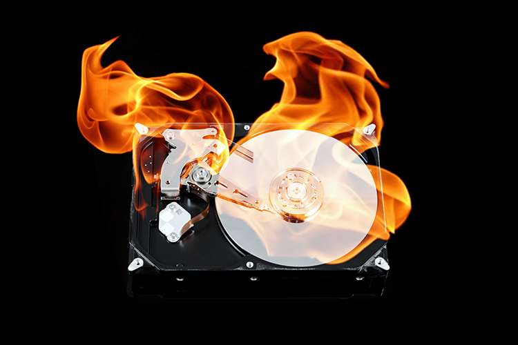 Burning hard drive illustrating why off-site backup storage protects photos from physical damage